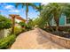 Paver walkway lined with lush landscaping and a pergola creates curb appeal at 1810 Lincoln Dr, Sarasota, FL 34236