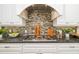 Close-up shot of stylish gas range with granite countertops, tile backsplash, and white cabinets at 1810 Lincoln Dr, Sarasota, FL 34236