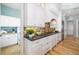 Bright kitchen with white cabinets, stone counters, stainless appliances, and wood floors at 1810 Lincoln Dr, Sarasota, FL 34236