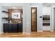 Charming wet bar featuring brick backsplash, granite countertop, black cabinets and stylish shelves at 1810 Lincoln Dr, Sarasota, FL 34236