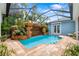 Enclosed pool with stone waterfall feature and lush landscaping at 1810 Lincoln Dr, Sarasota, FL 34236