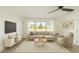 Bright living room with large windows, ceiling fan, neutral furniture, and decor at 21907 Cellini Ave, Port Charlotte, FL 33952