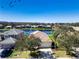 Aerial view of a charming home in a lakeside community with lush trees and a well-maintained front yard at 236 Golden Harbour Trl, Bradenton, FL 34212