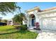 Charming single-story home featuring a well-manicured lawn, blue door, tile roof, and a two-car garage at 236 Golden Harbour Trl, Bradenton, FL 34212