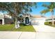 Charming single-story home featuring a well-manicured lawn, blue door, tile roof, and a two-car garage at 236 Golden Harbour Trl, Bradenton, FL 34212