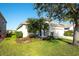 Charming single-story home featuring a well-manicured lawn, blue door, tile roof, and a two-car garage at 236 Golden Harbour Trl, Bradenton, FL 34212