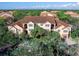 Beautiful exterior of this multistory condo with a brown roof, beige exterior walls, palm trees and mature trees surrounding it at 4152 Central Sarasota Pkwy # 727, Sarasota, FL 34238