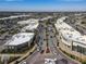 Aerial view of a commercial district with shops, restaurants, and a busy street with palm trees at 5697 Sheffield Greene Cir # 51, Sarasota, FL 34235