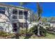 Charming condo featuring a screened lanai, balcony, lush landscaping, and a beautiful palm tree against a bright blue sky at 5697 Sheffield Greene Cir # 51, Sarasota, FL 34235