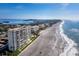 Expansive beachfront with pristine sands, and residential buildings, creating a luxurious coastal living experience at 605 Sutton Pl # 205, Longboat Key, FL 34228