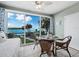 Bright dining area with scenic water views from expansive windows, complemented by a ceiling fan at 605 Sutton Pl # 205, Longboat Key, FL 34228