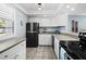 Functional kitchen with white cabinets, black appliances, and tiled flooring at 605 Sutton Pl # 205, Longboat Key, FL 34228