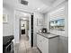 Bright kitchen with window, white cabinets, gray countertops, and tile floor at 605 Sutton Pl # 205, Longboat Key, FL 34228