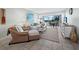Bright living room featuring a cozy sitting area and balcony with a view of a waterfront at 605 Sutton Pl # 205, Longboat Key, FL 34228