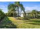 Expansive backyard featuring lush green lawn, mature trees, and tropical plants, offering privacy and serene outdoor space at 11422 Griffith Park Ter, Bradenton, FL 34211