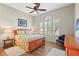 Cozy bedroom features a ceiling fan, wood floor, shutters, area rugs, and a chair at 11422 Griffith Park Ter, Bradenton, FL 34211