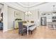 Open-concept dining area adjacent to the kitchen with a decorative chandelier and stainless steel appliances in background at 11422 Griffith Park Ter, Bradenton, FL 34211