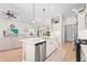 Open concept kitchen with island, stainless steel appliances, and seamless flow to living and dining areas at 11422 Griffith Park Ter, Bradenton, FL 34211