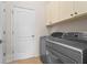 Laundry room features a washer, dryer, tile floor, and cabinets at 11422 Griffith Park Ter, Bradenton, FL 34211
