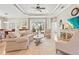Spacious living room with elegant tray ceiling, ceiling fan, and sliding glass doors to the outdoor living area at 11422 Griffith Park Ter, Bradenton, FL 34211