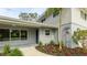 Inviting exterior of a home featuring a well-manicured garden, a covered entrance, and a light gray color scheme at 3348 S Seclusion Dr, Sarasota, FL 34239