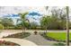 Charming front yard showcasing a beautifully landscaped walkway with flowers, plants, and a tranquil water view at 3348 S Seclusion Dr, Sarasota, FL 34239