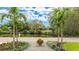 Attractive front yard with lush landscaping, palm trees, and a lovely water view enhancing curb appeal at 3348 S Seclusion Dr, Sarasota, FL 34239