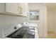 Laundry room with GE washer and dryer and white cabinets at 3348 S Seclusion Dr, Sarasota, FL 34239