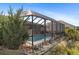 Pool with screened-in enclosure next to the house and landscaping along the side at 339 Rio De Janeiro Ave, Punta Gorda, FL 33983