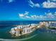 Aerial view featuring waterfront homes along the coast with beautiful sky and bridges in the distance at 378 Golden Gate Pt # 6, Sarasota, FL 34236