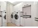 Modern laundry room with sleek white cabinets, countertops and efficient washer and dryer units at 378 Golden Gate Pt # 6, Sarasota, FL 34236