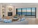Inviting living room featuring a stone fireplace, comfortable seating, and panoramic water views at 378 Golden Gate Pt # 6, Sarasota, FL 34236
