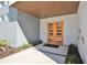 Modern entrance with vibrant orange doors, wood ceiling, professional landscaping, and a stylish walkway at 3939 Higel Ave, Sarasota, FL 34242