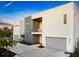 Modern two-story home with a gray and white facade, balcony, gray garage door, and landscaped front yard at 3939 Higel Ave, Sarasota, FL 34242