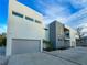 Contemporary home showcasing clean lines, a gray and white exterior, a balcony, and a spacious driveway at 3939 Higel Ave, Sarasota, FL 34242