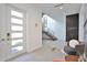 Bright foyer with staircase, accent wall, modern decor, and seating area, creating a welcoming entry space at 3939 Higel Ave, Sarasota, FL 34242