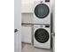 Efficient laundry room with stacked washer and dryer units and additional storage at 3939 Higel Ave, Sarasota, FL 34242