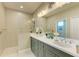 Spacious bathroom featuring double sinks, a large mirror, and a sleek walk-in shower at 4514 Big Woods Way, Parrish, FL 34219