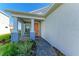 Charming entryway with tiled porch, decorative plants, an orange front door and blue siding at 4514 Big Woods Way, Parrish, FL 34219