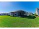 Back exterior of home featuring screened patio and manicured backyard at 4514 Big Woods Way, Parrish, FL 34219