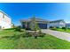 Attractive single-story home featuring a well-kept lawn, decorative landscaping, and a driveway to an attached garage at 4514 Big Woods Way, Parrish, FL 34219