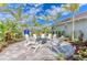 Outdoor fire pit with Adirondack chairs encircled by tropical landscaping, perfect for gatherings at 4514 Big Woods Way, Parrish, FL 34219