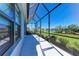 Covered and screened patio with chairs overlooking the serene lake at 4514 Big Woods Way, Parrish, FL 34219