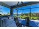 Screened patio featuring an outdoor kitchen, ceiling fan, and a tranquil water view at 4514 Big Woods Way, Parrish, FL 34219