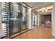 Modern wine display with glass enclosure showcasing an extensive collection in an elegant space with wood floors and custom lighting at 4534 Trento Pl, Bradenton, FL 34211