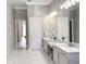 Bright bathroom with double sinks, marble floors, and elegant lighting fixtures at 5305 Brookgrove Dr, Sarasota, FL 34238