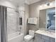 Serene bathroom featuring marble tile, modern fixtures, a bathtub with a shower, and a vanity with countertop at 5305 Brookgrove Dr, Sarasota, FL 34238