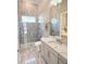 Bright bathroom features a glass shower, white vanity with marble countertop and views of the bedroom at 5305 Brookgrove Dr, Sarasota, FL 34238
