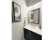 Modern powder room with custom vanity, elegant fixtures, and decorative artwork at 5305 Brookgrove Dr, Sarasota, FL 34238