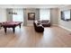 Open game room with pool table, leather sofa, hardwood floors and large windows at 5305 Brookgrove Dr, Sarasota, FL 34238